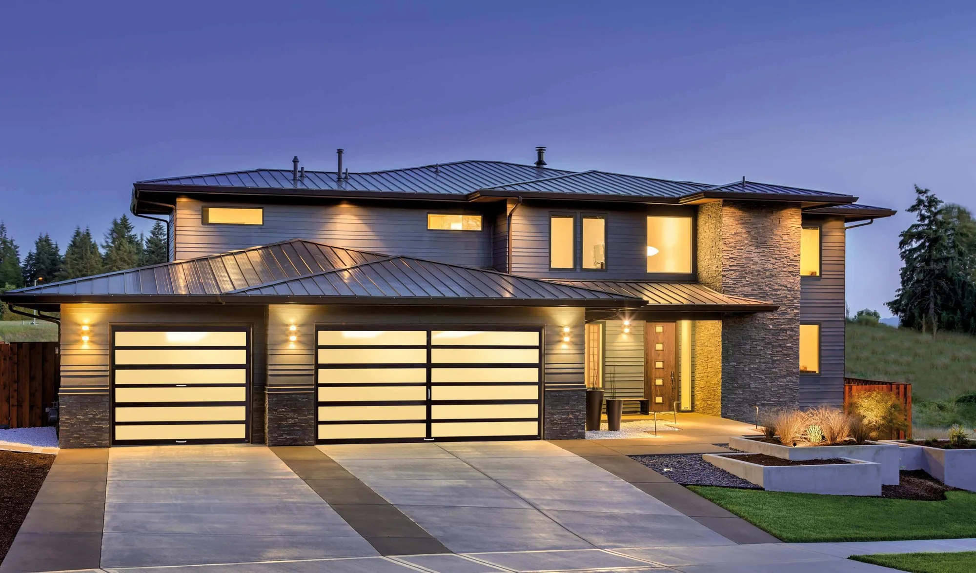 Full view glass garage doors lit at dusk