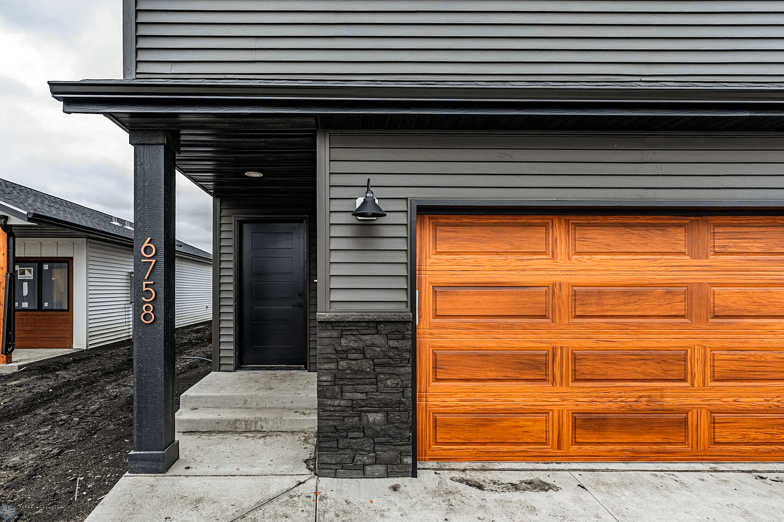 Modern home with a woodtone garage door installed near Aviston, IL