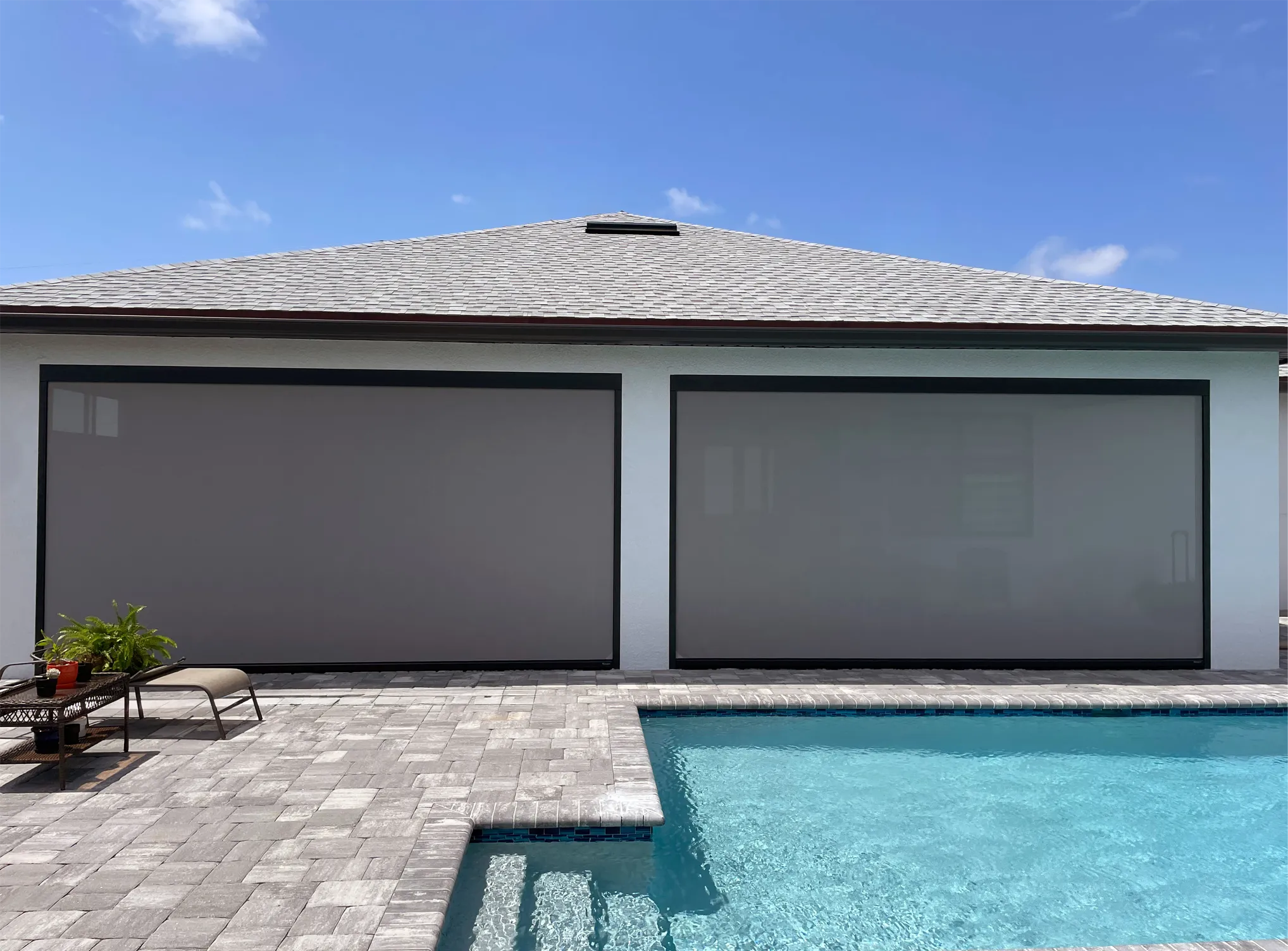 Retractable vinyl screens around a pool patio